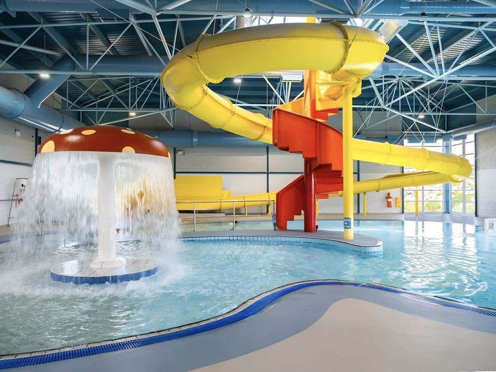 A swimming pool area with a water slide and mushroom fountain at Static Caravan Mallard Rise 22 Hoburne Devon Bay in Paignton