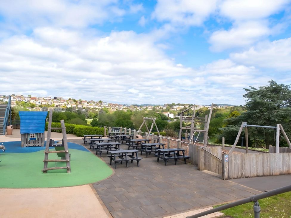 An outdoor playground with picnic tables and swings at Static Caravan Mallard Rise 22 Hoburne Devon Bay Paignton