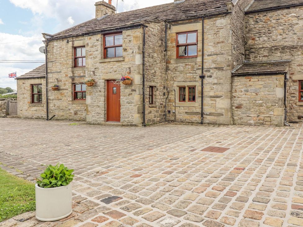 An outdoor area with a stone house and a planter at Orcaber Farmhouse Lancaster