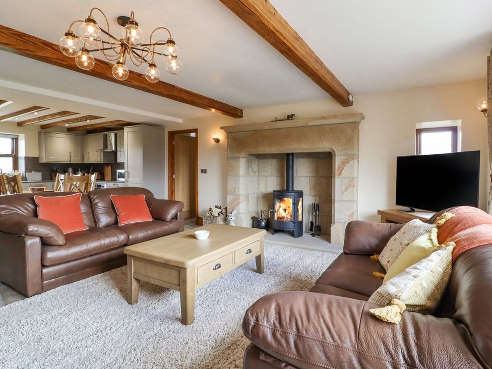 A living room with sofas and a fireplace at Orcaber Farmhouse in Lancaster