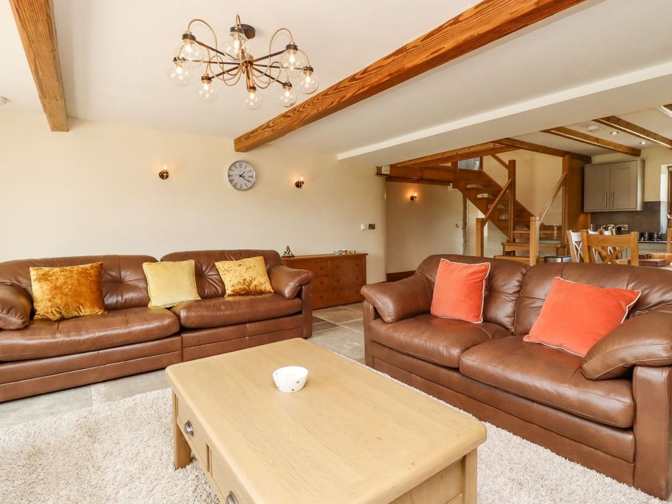 A living room with a sofa and coffee table at Orcaber Farmhouse Lancaster