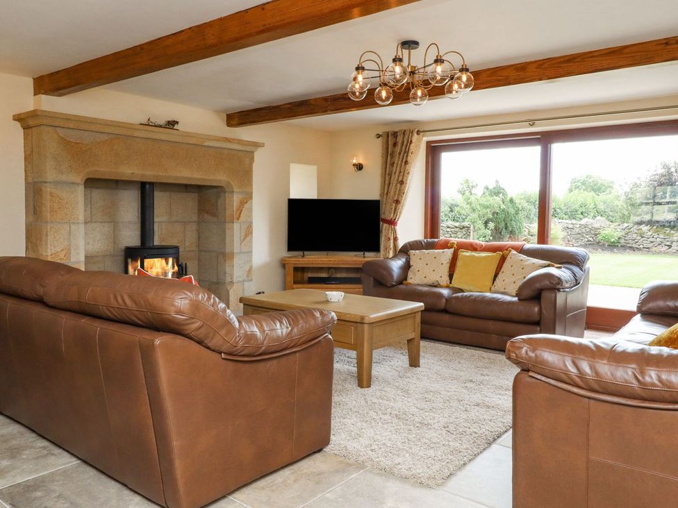 A living room featuring sofas, a coffee table and a fireplace at Orcaber Farmhouse in Lancaster