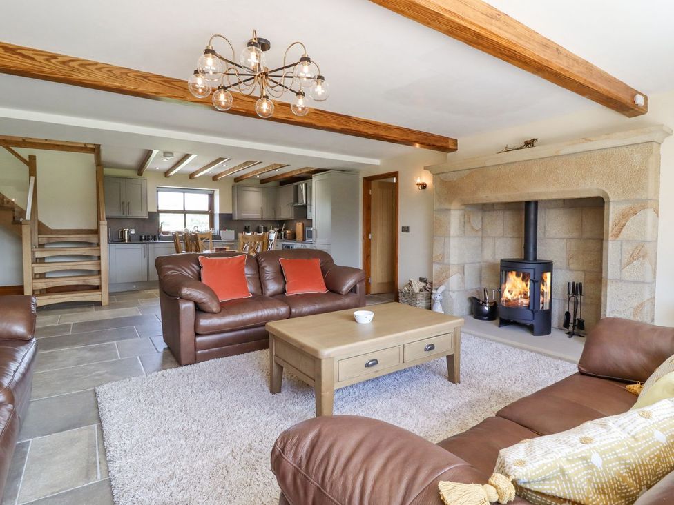 A living room with a fireplace and sofas at Orcaber Farmhouse in Lancaster