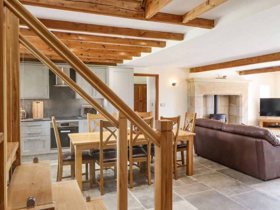 A kitchen with dining table and sofa at Orcaber Farmhouse in Lancaster