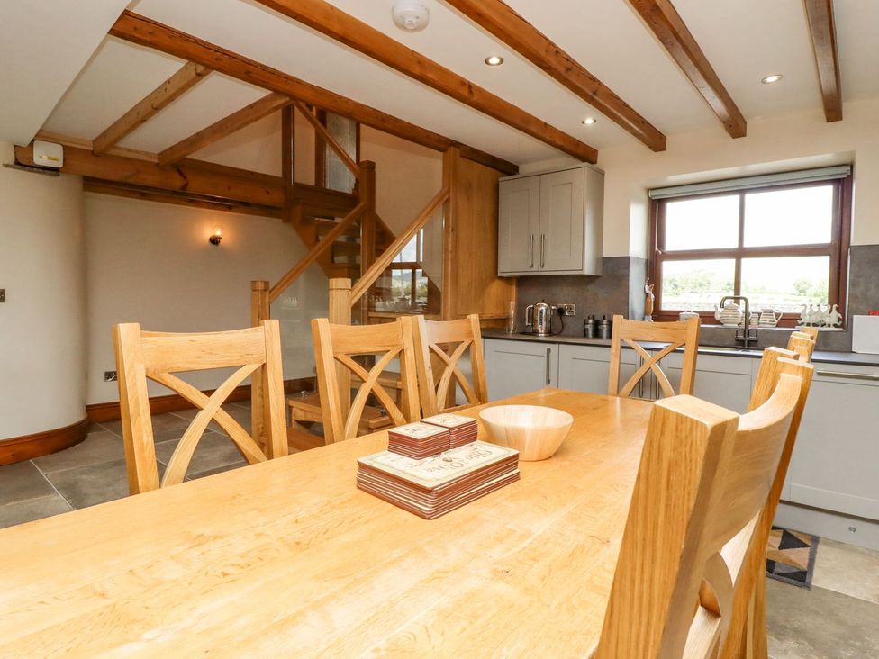 A dining area with wooden table and chairs at Orcaber Farmhouse in Lancaster
