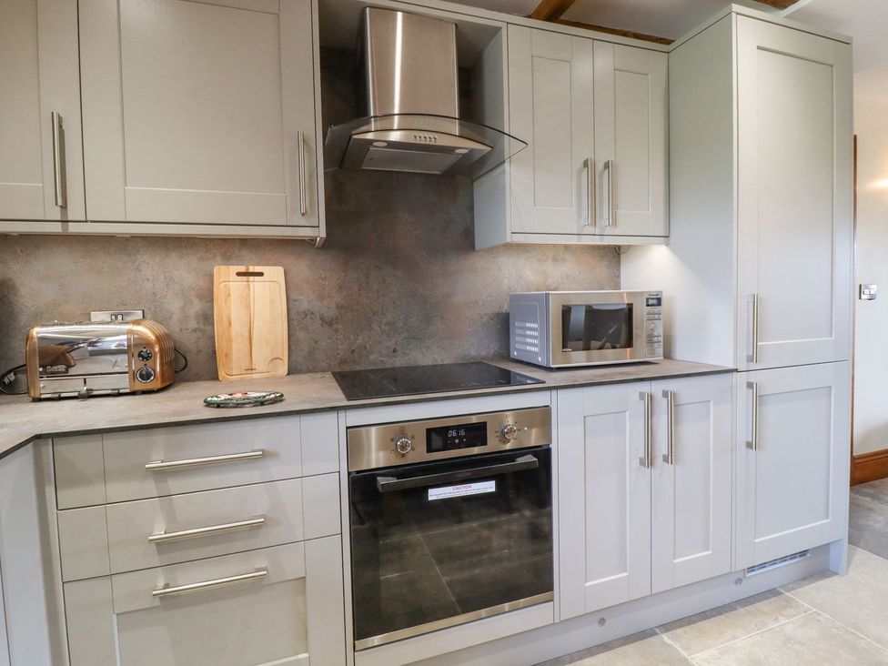A kitchen with appliances including an oven and microwave at Orcaber Farmhouse Lancaster