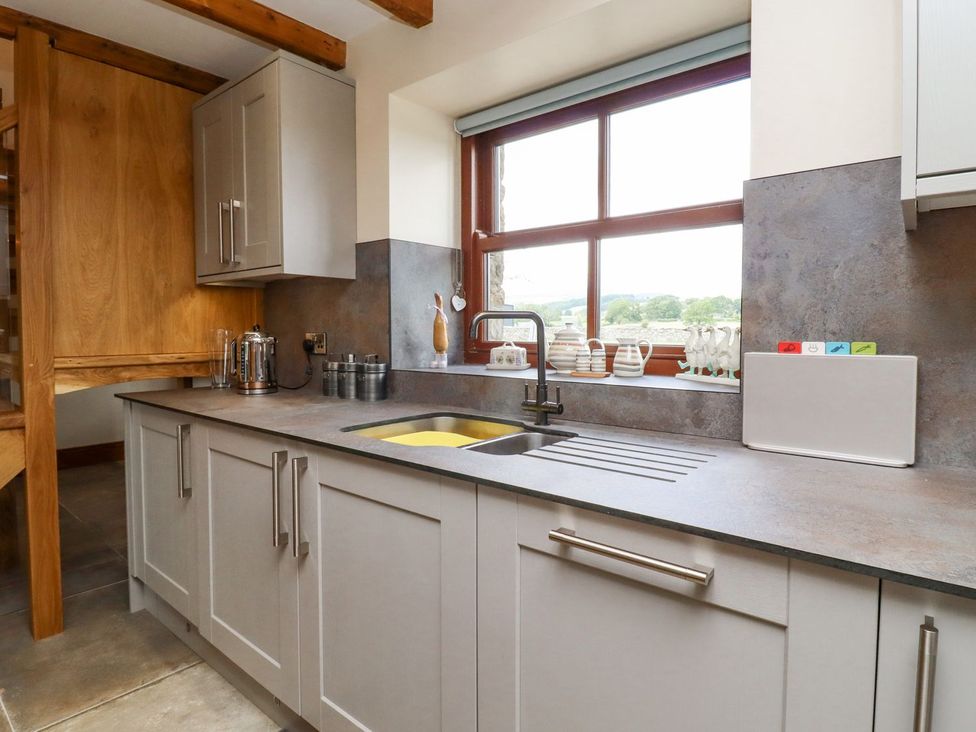 A kitchen with a sink and window at Orcaber Farmhouse in Lancaster