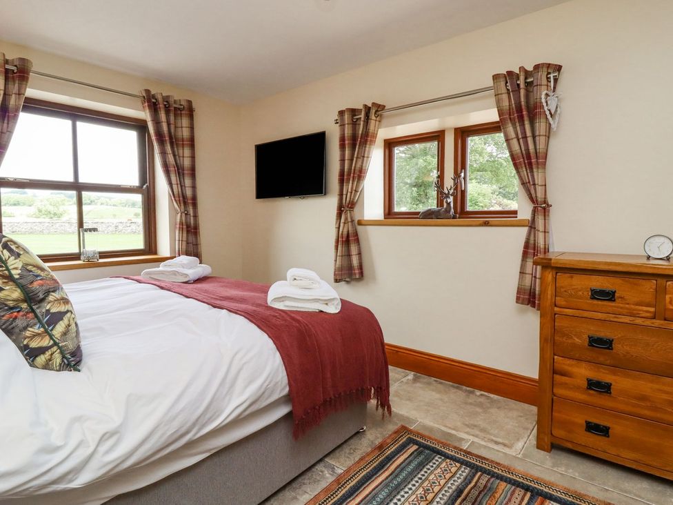 A bedroom with a bed and dresser at Orcaber Farmhouse in Lancaster