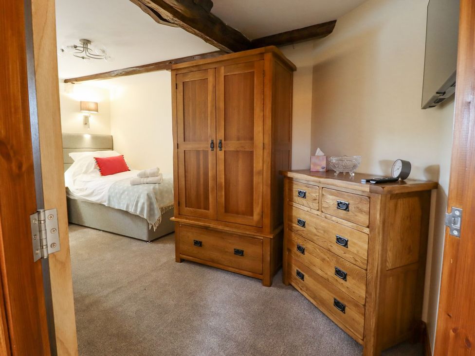 A bedroom with a wardrobe and chest of drawers at Orcaber Farmhouse in Lancaster