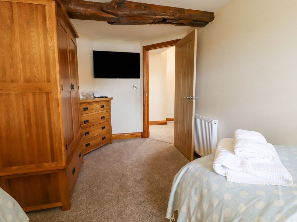 A bedroom with a wardrobe and dresser at Orcaber Farmhouse in Lancaster