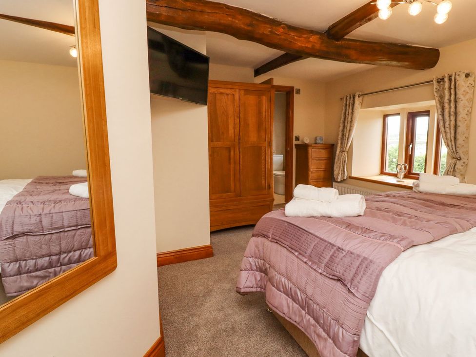 A bedroom with a bed and wardrobe at Orcaber Farmhouse in Lancaster