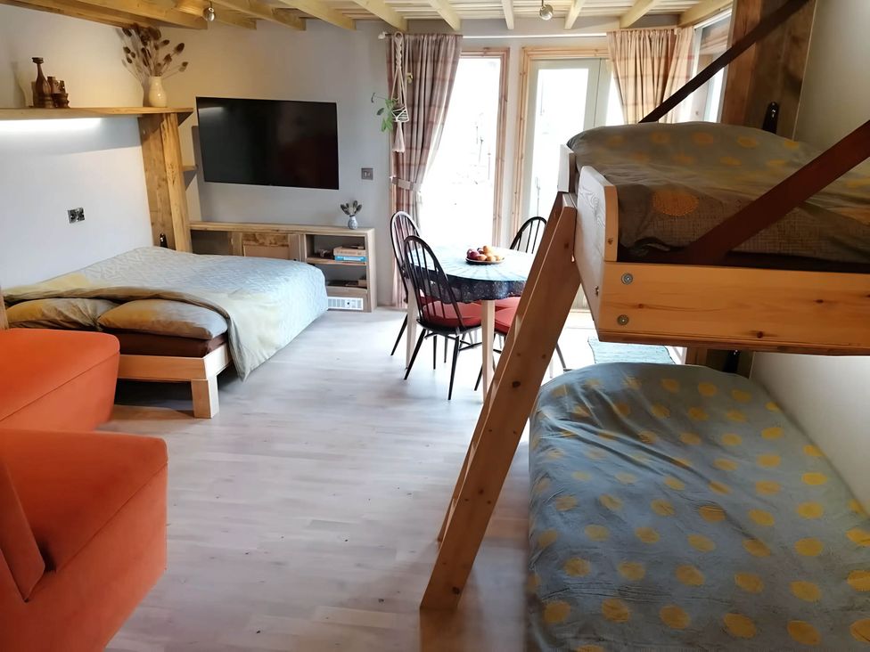 A studio with a bed, bunk bed, table, and television at Stone Moor Lodge, Justin's Peak District Base Camp Sheffield