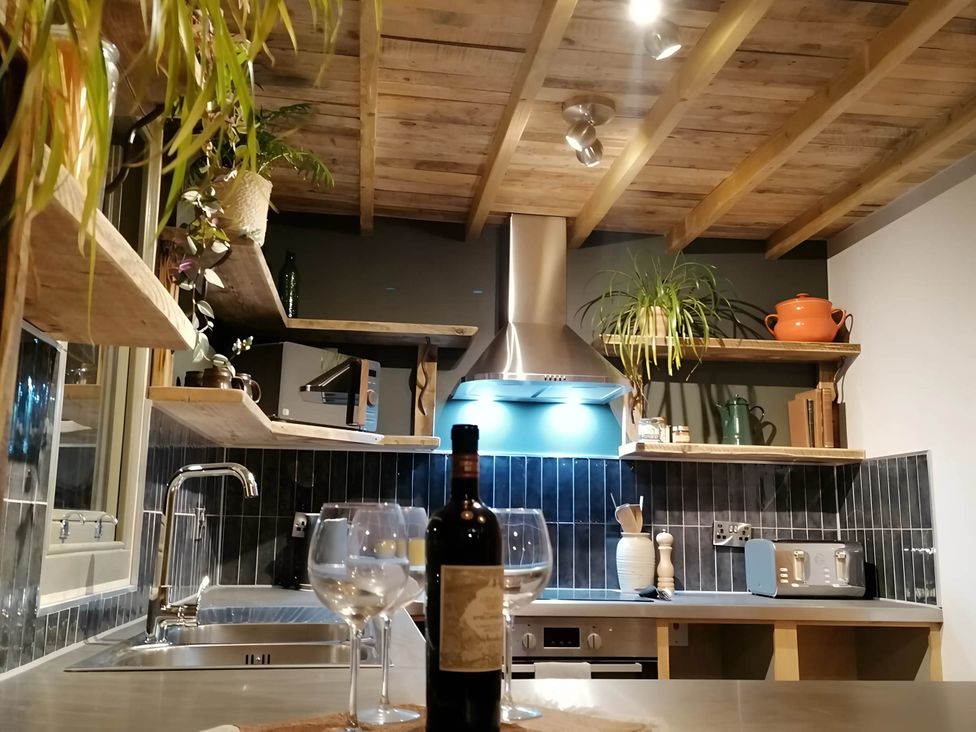 A kitchen with wine glasses and a bottle at Stone Moor Lodge, Justin's Peak District Base Camp, Sheffield