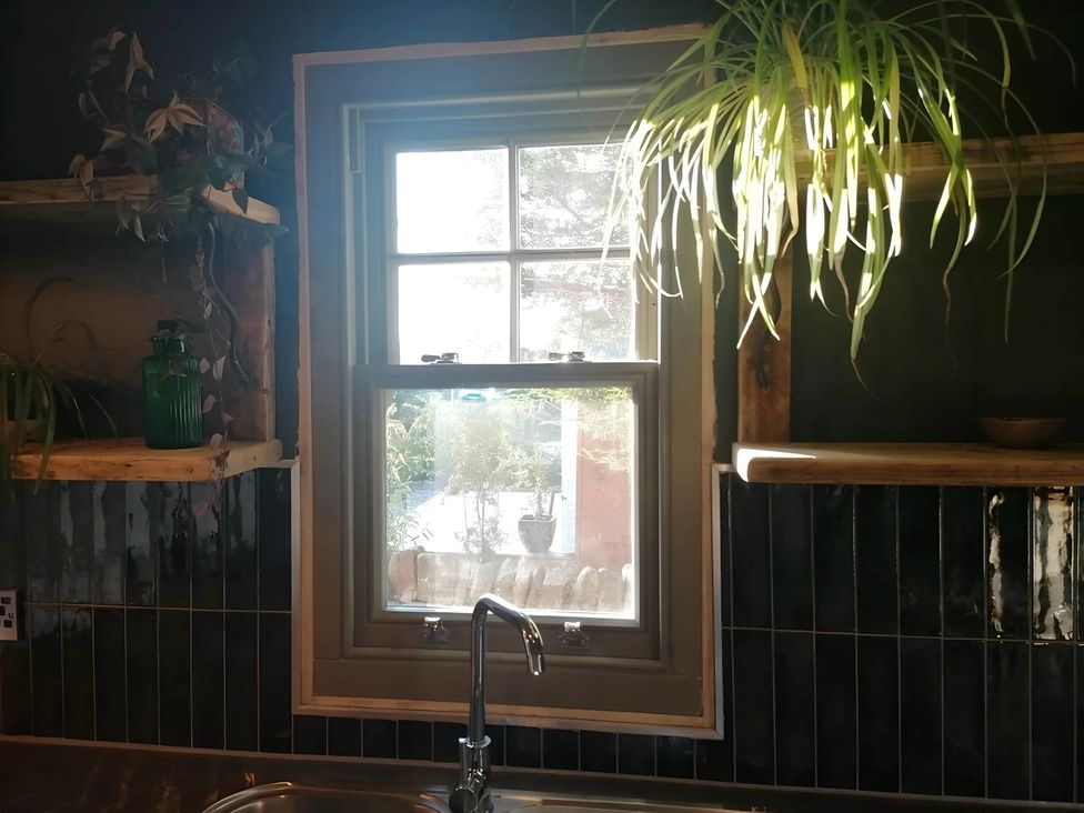A kitchen with a window, sink, and shelves at Stone Moor Lodge, Justin's Peak District Base Camp, Sheffield