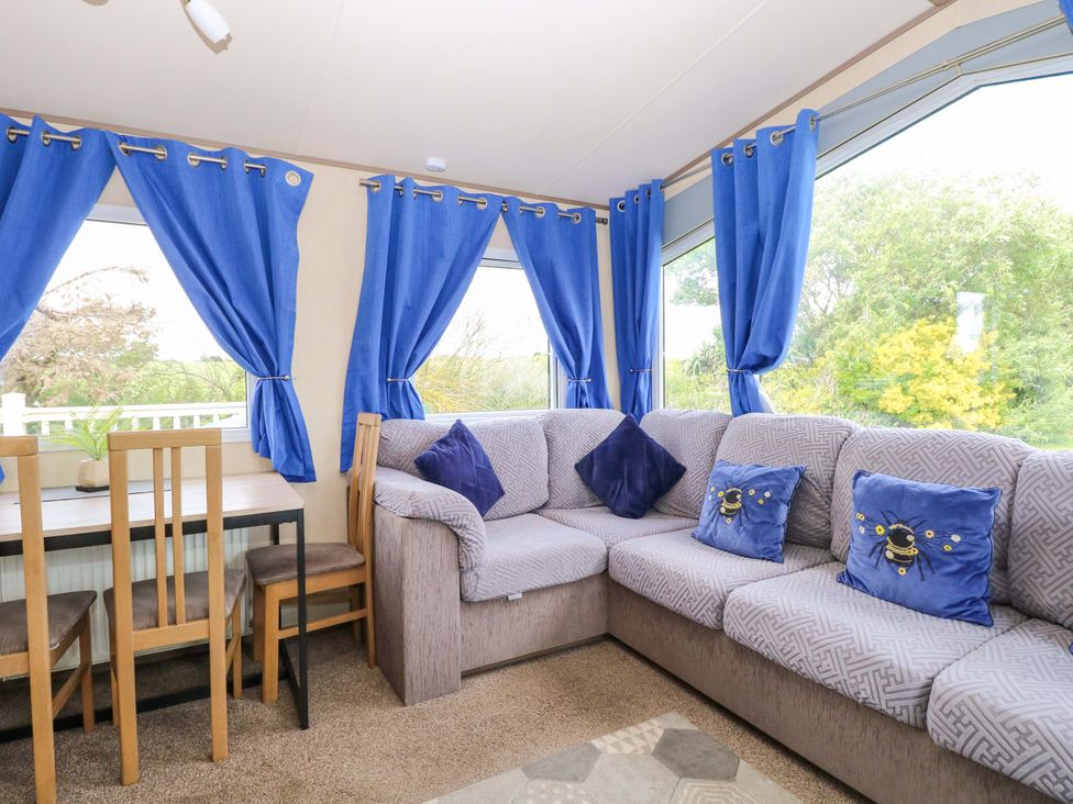 A living room with a sofa and dining table at PK Sunset View in Corton