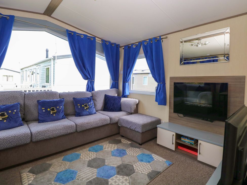 A living room with a sofa and television at PK Sunset View in Corton