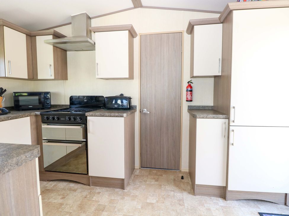 A kitchen with cabinets and appliances at PK Sunset View in Corton