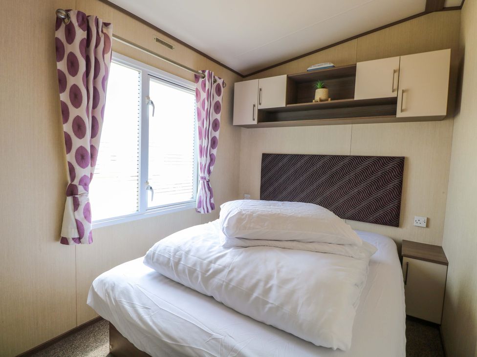 A bedroom with a bed and curtains at PK Sunset View in Corton