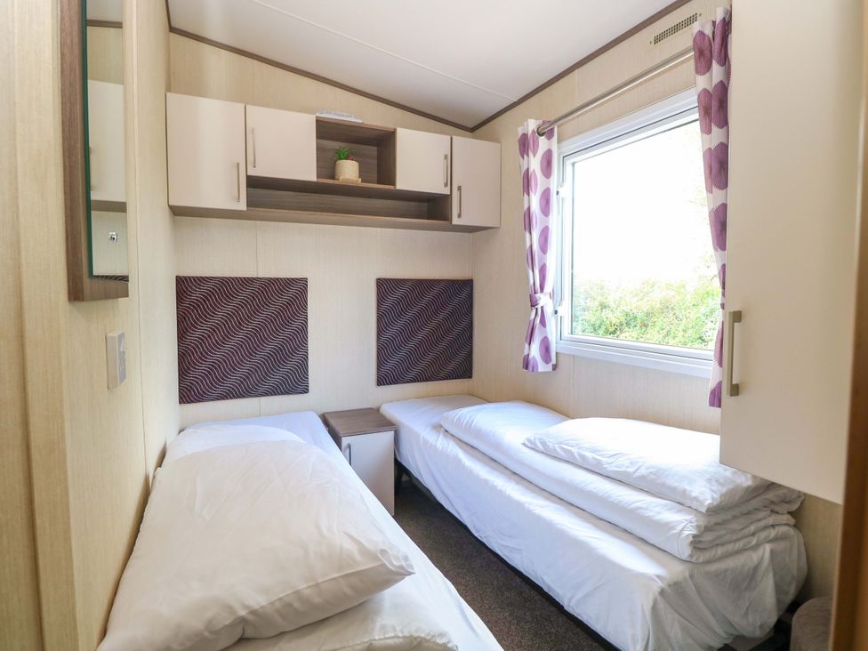 A bedroom with two beds and a shelf at PK Sunset View in Corton