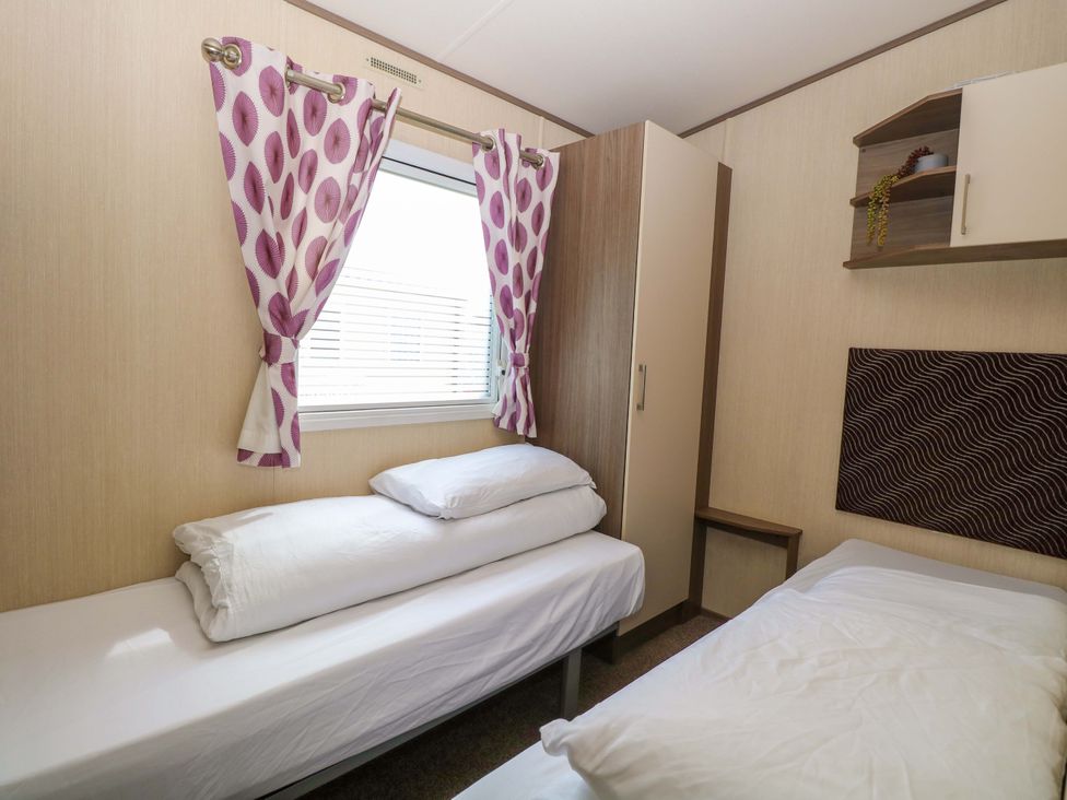 A bedroom with two beds and a wardrobe at PK Sunset View in Corton