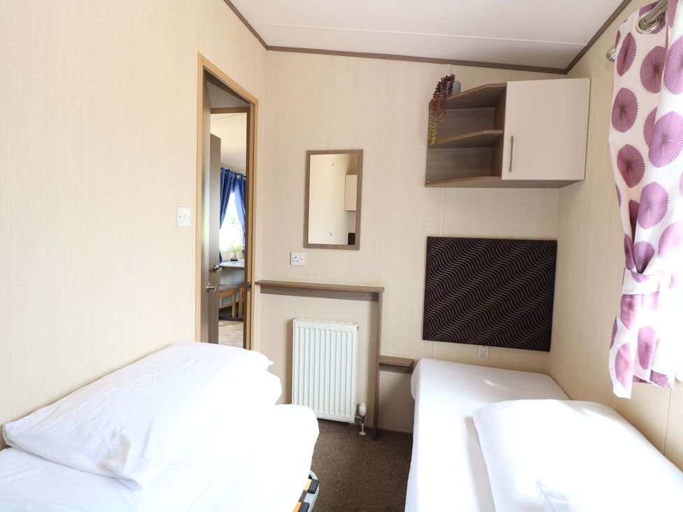 A bedroom with beds and a mirror at PK Sunset View in Corton