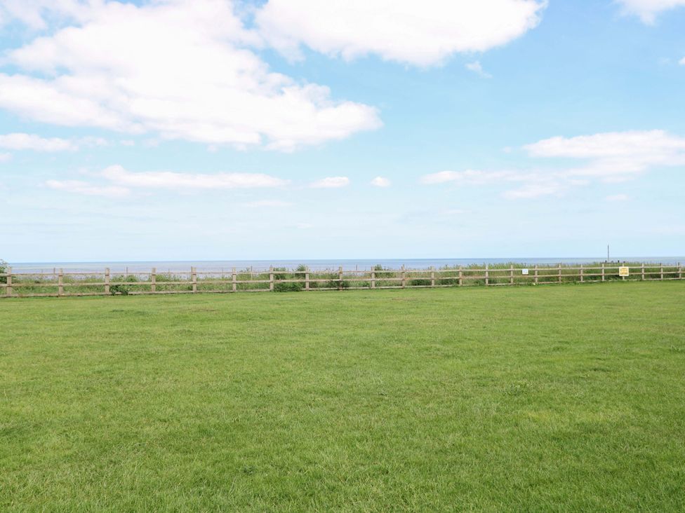 An outdoor area with grass and a wooden fence at PK Sunset View in Corton