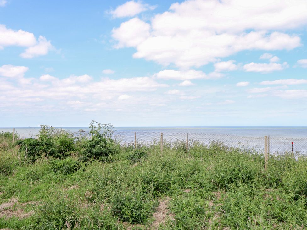 A view of the sea with grass and a fence at PK Sunset View Corton