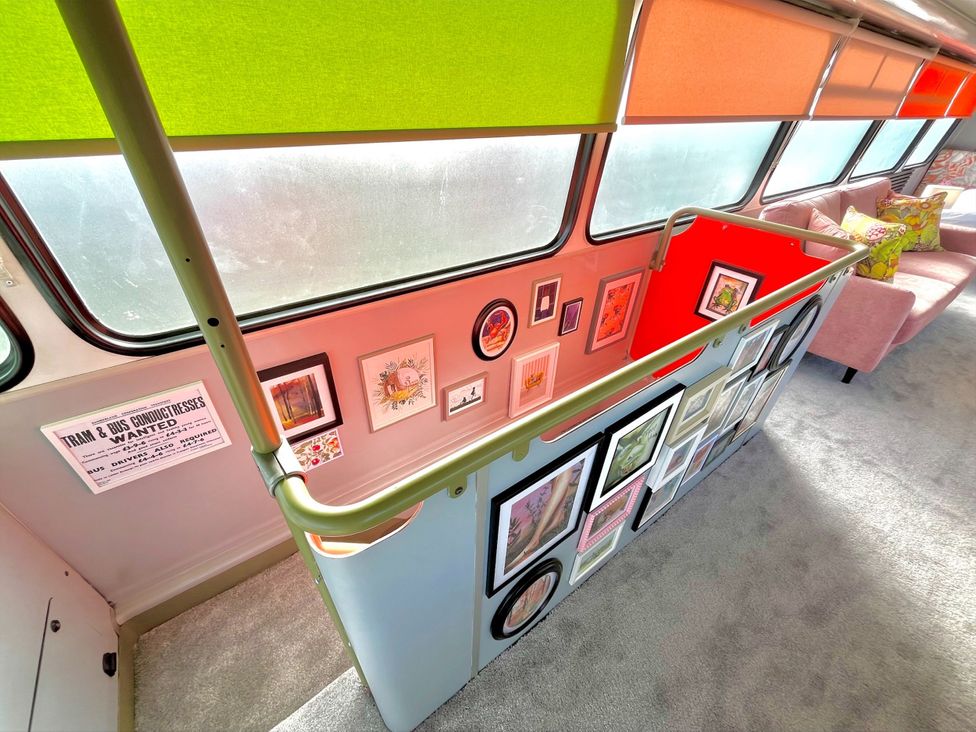 A bus interior with framed artwork and a sofa at No 1 The Depot in Gateshead