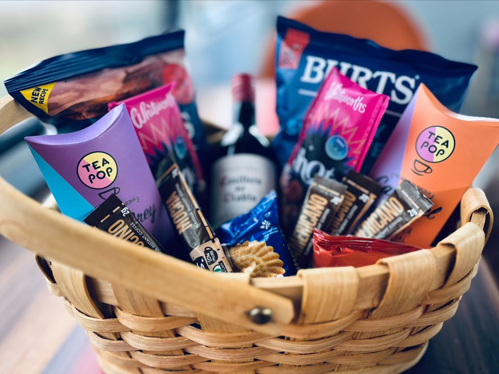 A basket filled with snacks and a wine bottle