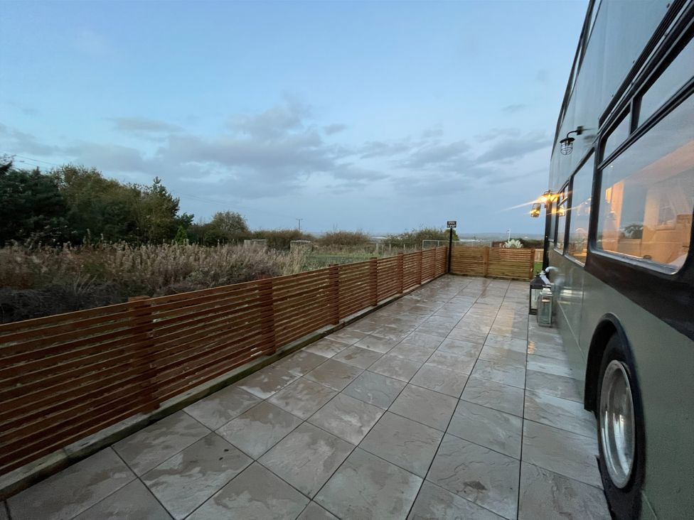 An outdoor area with a bus and a wooden fence at No 1 The Depot in Gateshead