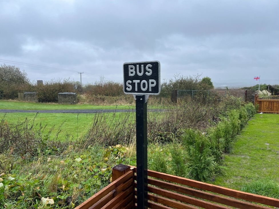 A bus stop sign with grass and a fence in the background at No 1 The Depot Gateshead