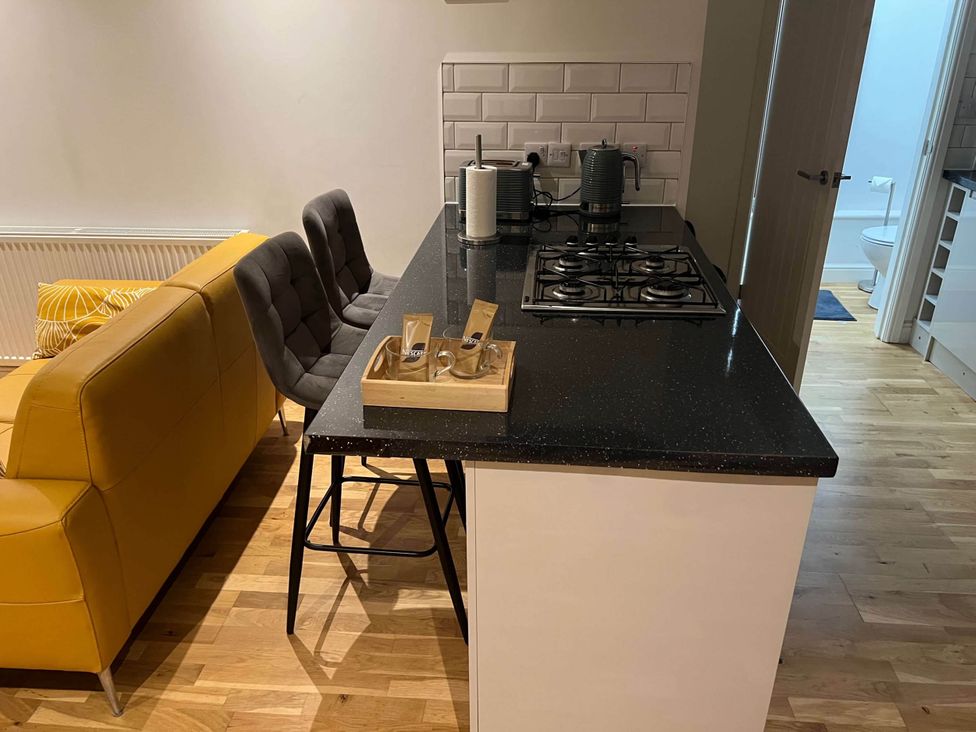 A kitchen with counter and stools at Seaside Cottage Escape in Paignton