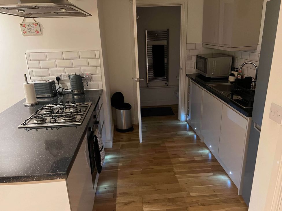 A kitchen with appliances and cabinets at Seaside Cottage Escape in Paignton