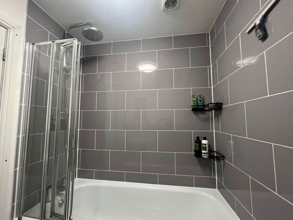 A bathroom with a shower and bathtub at Seaside Cottage Escape in Paignton