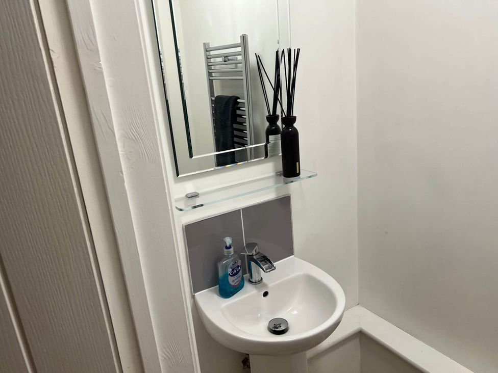 A bathroom with a sink and mirror at Seaside Cottage Escape in Paignton