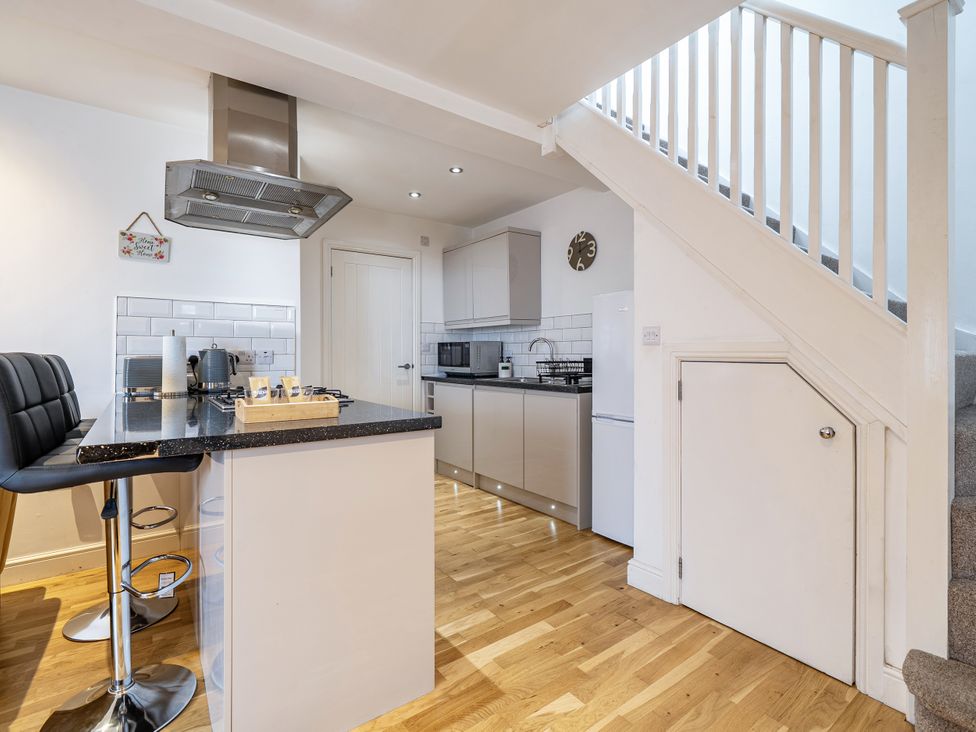 A kitchen with a stove and refrigerator at Seaside Cottage Escape in Paignton