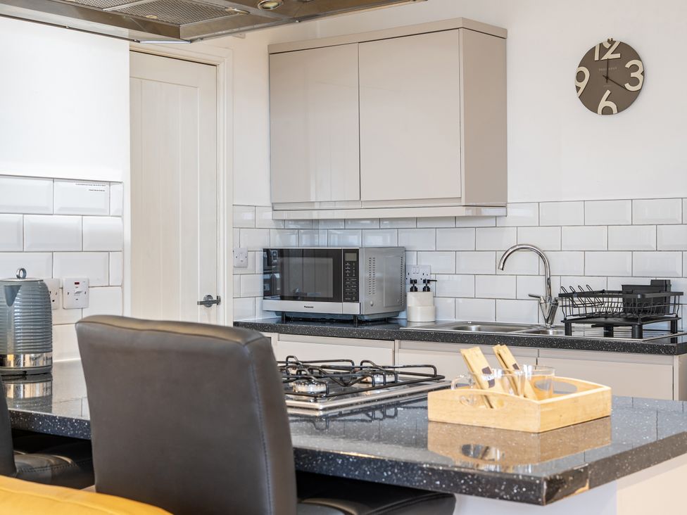 A kitchen with a microwave and sink at Seaside Cottage Escape in Paignton
