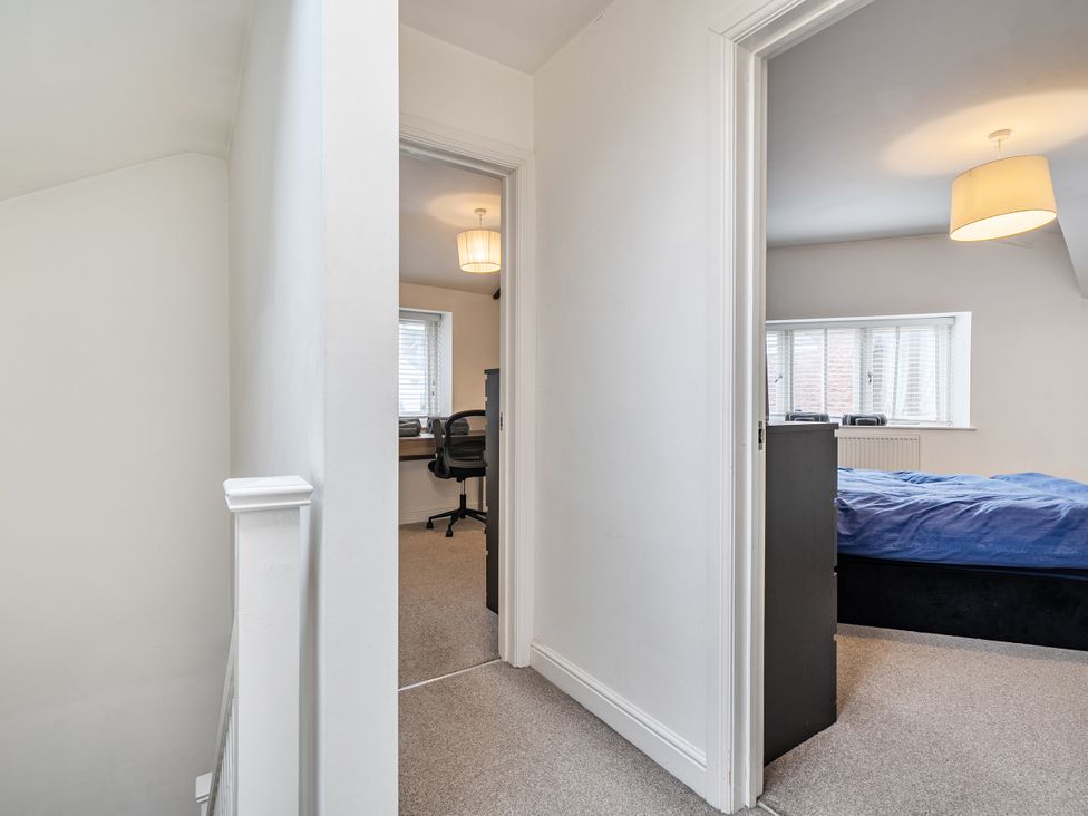 A hallway with doors leading to a bedroom and an office area at Seaside Cottage Escape in Paignton