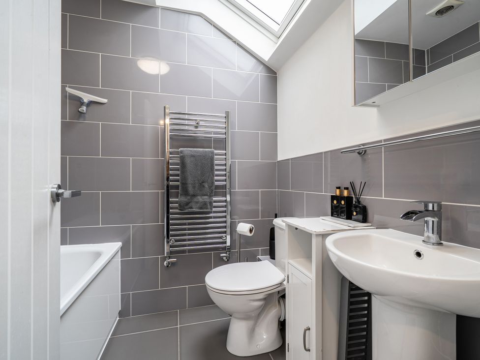 A bathroom with a bath tub, sink, and toilet at Seaside Cottage Escape in Paignton