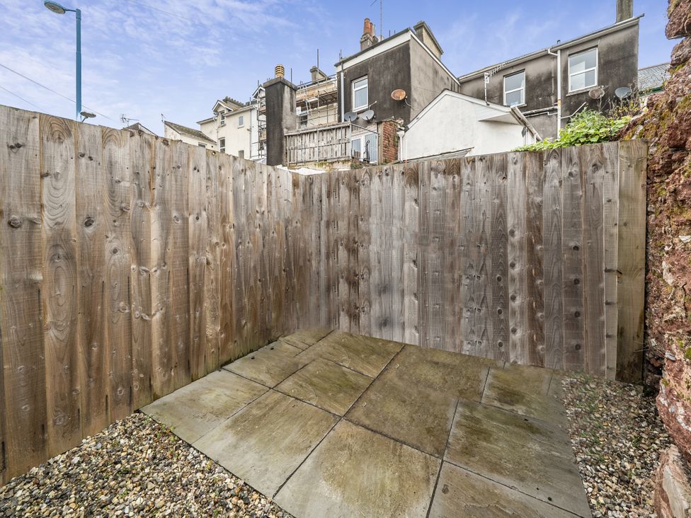 An outdoor area with paving stones and wooden fencing at Seaside Cottage Escape in Paignton