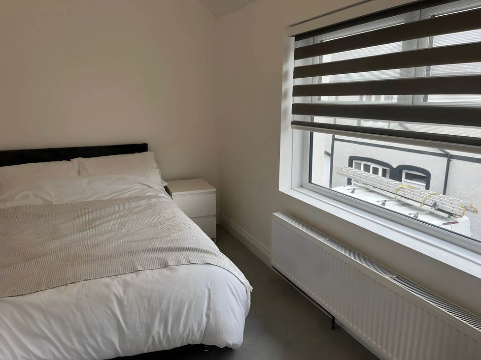 A bedroom with a bed and nightstand at Llangollen - House - Sleeps 8- Garden in Llangollen