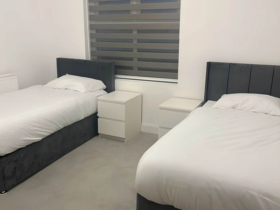 A bedroom with two beds and a window at Llangollen - House - Sleeps 8- Garden in Llangollen