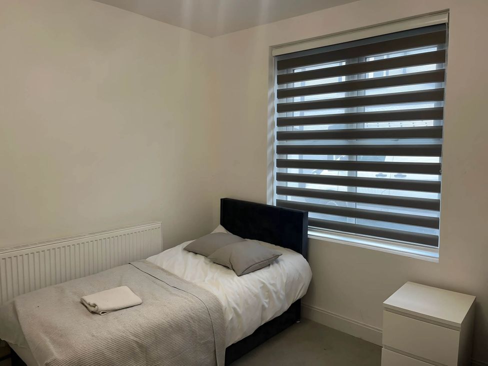 A bedroom with a bed and window at Llangollen - House - Sleeps 8- Garden, Llangollen