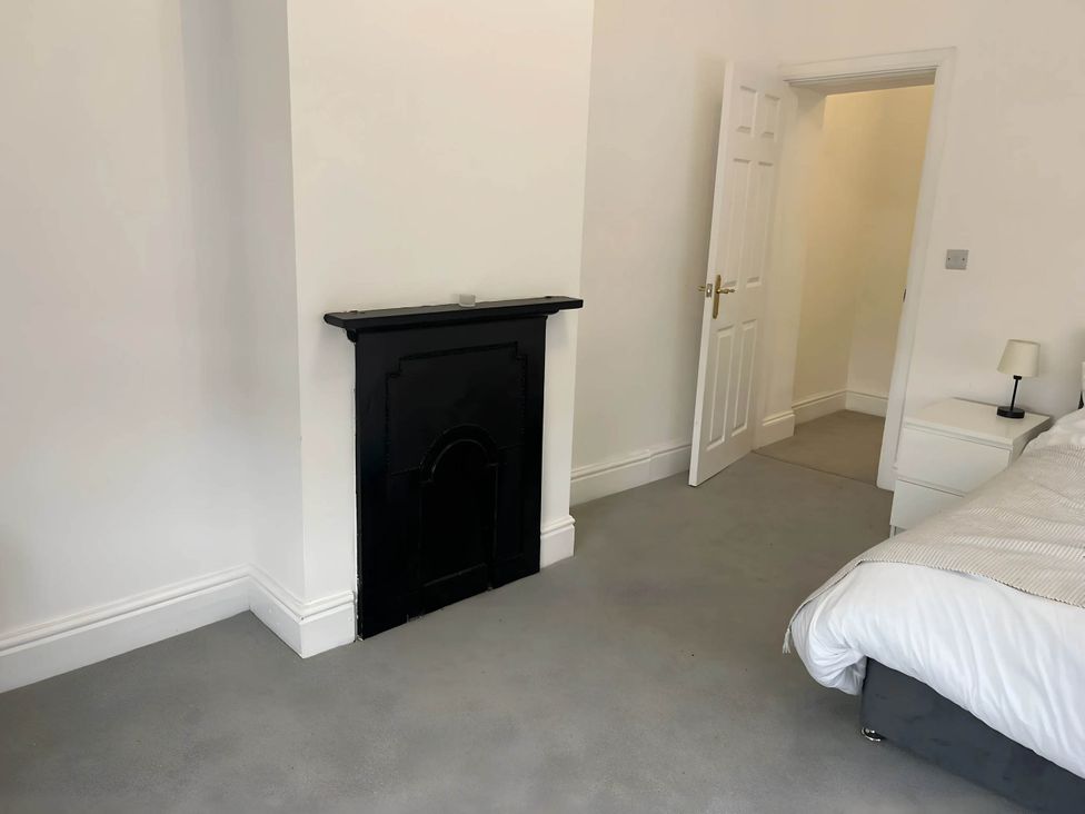 A bedroom with a fireplace and bed at Llangollen - House - Sleeps 8- Garden in Llangollen