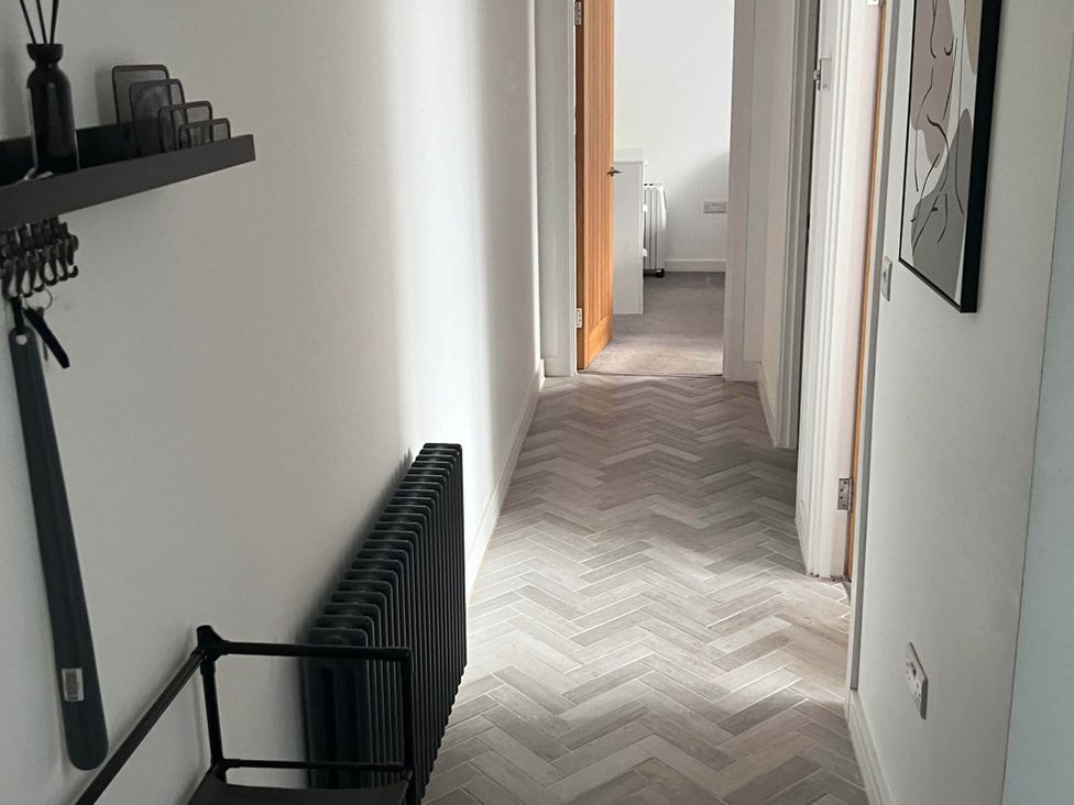 A hallway with a radiator and doors at Modern Seaside Cottage - Sleeps 5 Paignton