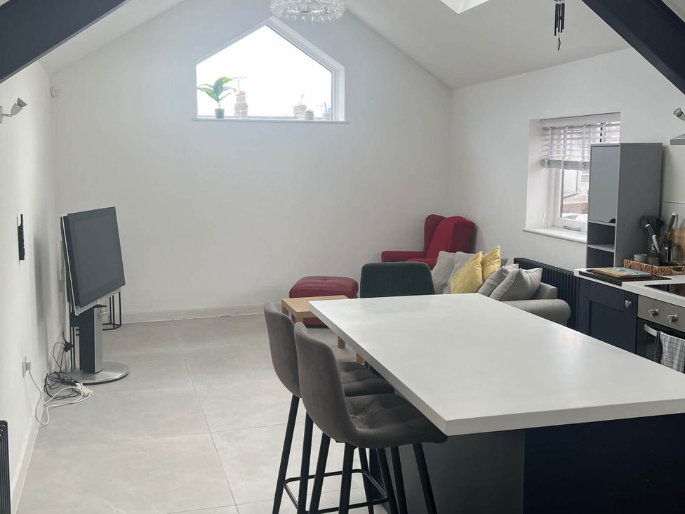 A living room with a television and bar stools at Modern Seaside Cottage - Sleeps 5, Paignton