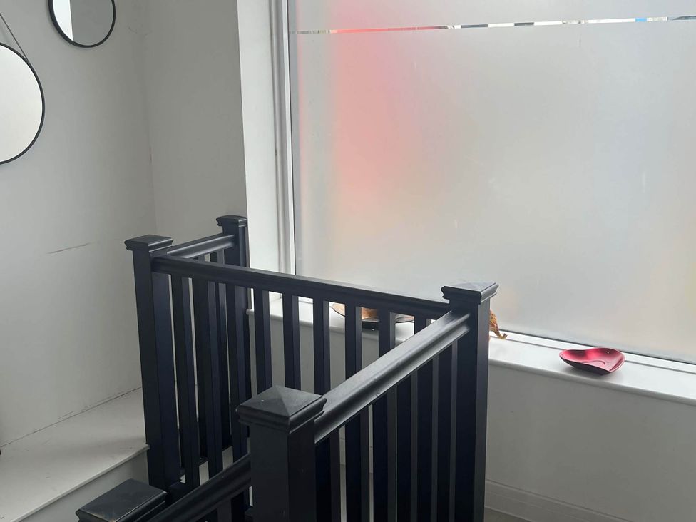 A staircase with a handrail and mirrors at Modern Seaside Cottage - Sleeps 5, Paignton