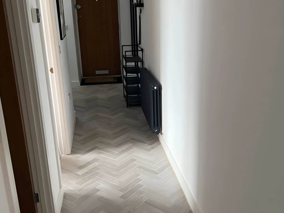 A hallway with a door and a coat rack at Modern Seaside Cottage - Sleeps 5, Paignton