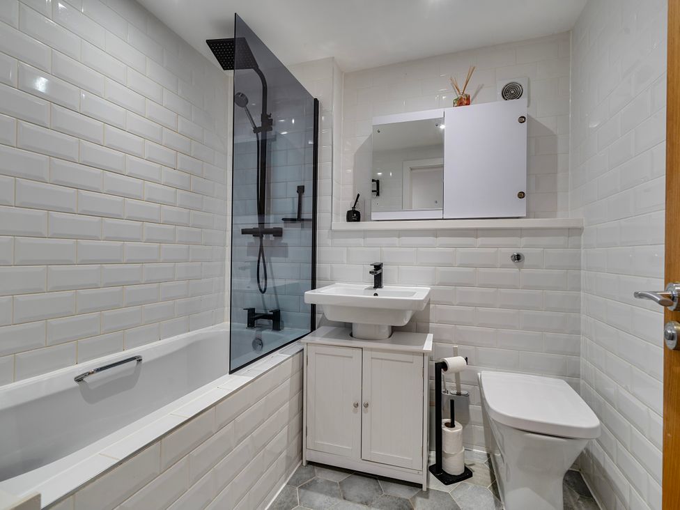 A bathroom with a bathtub, shower, sink, and toilet at Modern Seaside Cottage - Sleeps 5 in Paignton