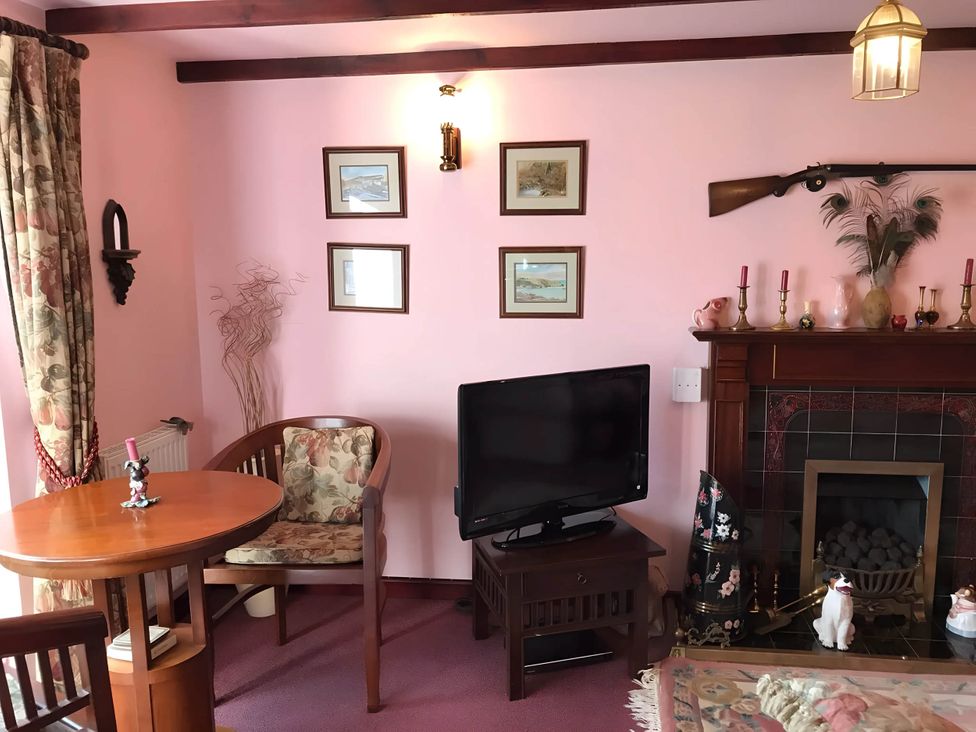 A living room with a table and television at Converted Stone Barn -20 Acres - Farm Animals! in Corwen